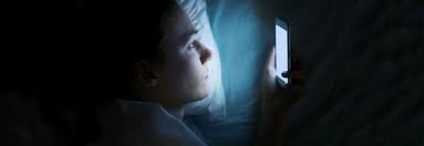 Person using smartphone at night, disrupting sleep and mental health